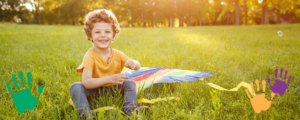 Boy Sitting in Grass with Kite